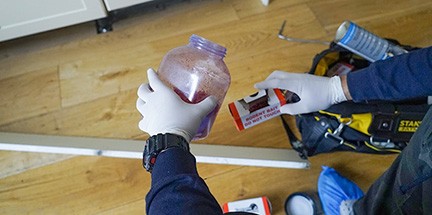 Technician puts mice bait in a box.